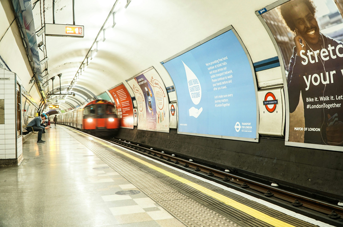 Mídias OOH em estação de metro, fixadas na parede.