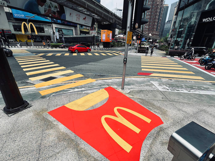 Marketing do MC Donalds no qual as faixas de pedestre foram pintadas de amarelo, simulando batatinhas saindo de uma embalagem clássica da marca.