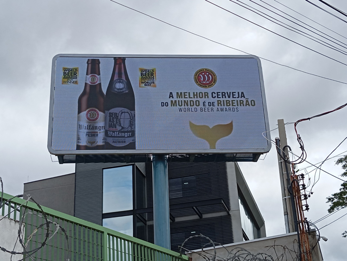 Outdoor digital Nobile em avenida de Ribeirão Preto, exibindo anúncio dinâmico de cervejaria.