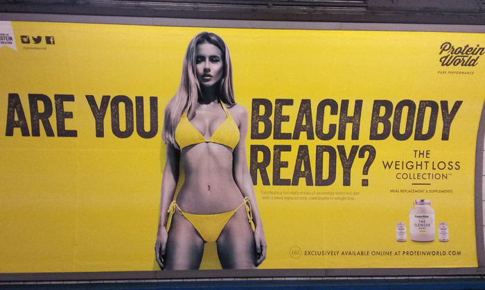 Campanhas de outdoor: anúncio da Protein World no metrô, fundo amarelo, modelo de biquíni amarelo ao lado do texto ‘Are you beach body ready?