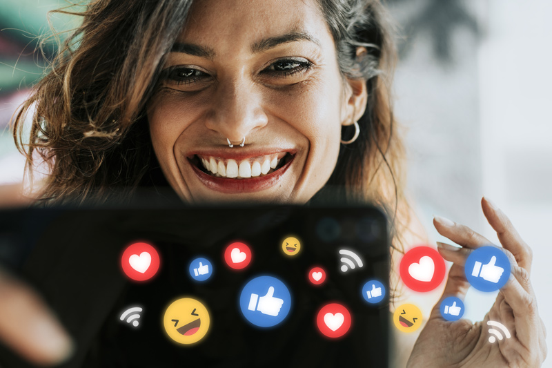 Mulher consumindo mídias digitais em smartphone, utilizando redes sociais.