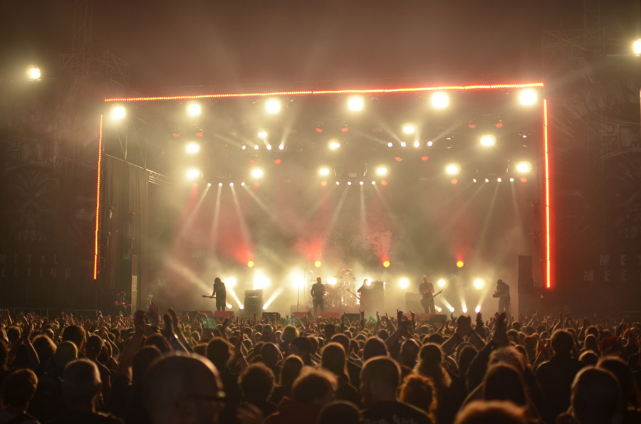 Show ao vivo: banda em palco iluminado se apresentando para plateia lotada